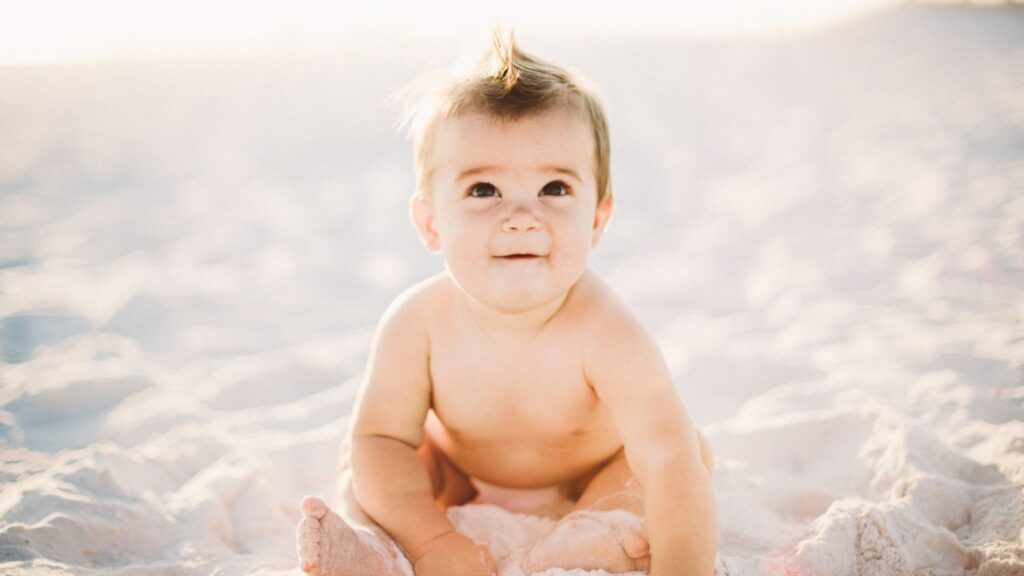 baby sitting on sand
