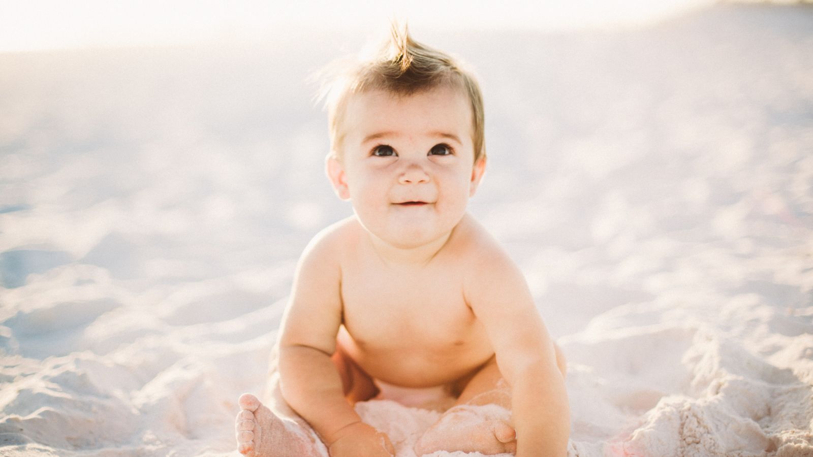 baby sitting on sand