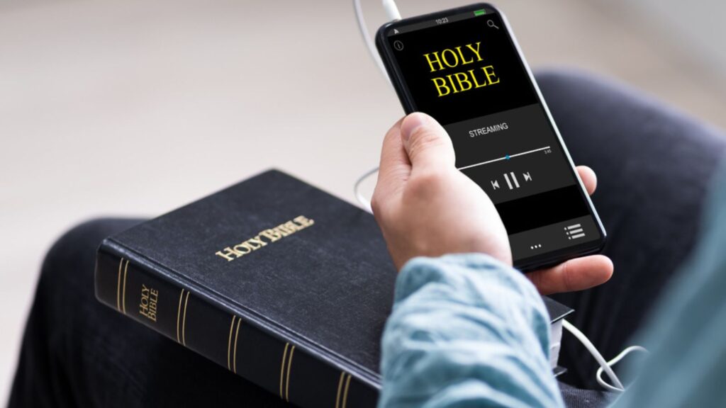 Christian Man Reading Bible Book On Phone And Praying