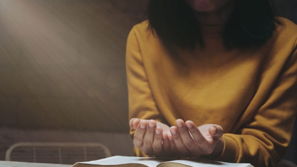 Women pray for God's blessings for a better life. Christian Life Crisis Prayer to God . Human hands pray to God with Scriptures. Believe in the good. Hold hands