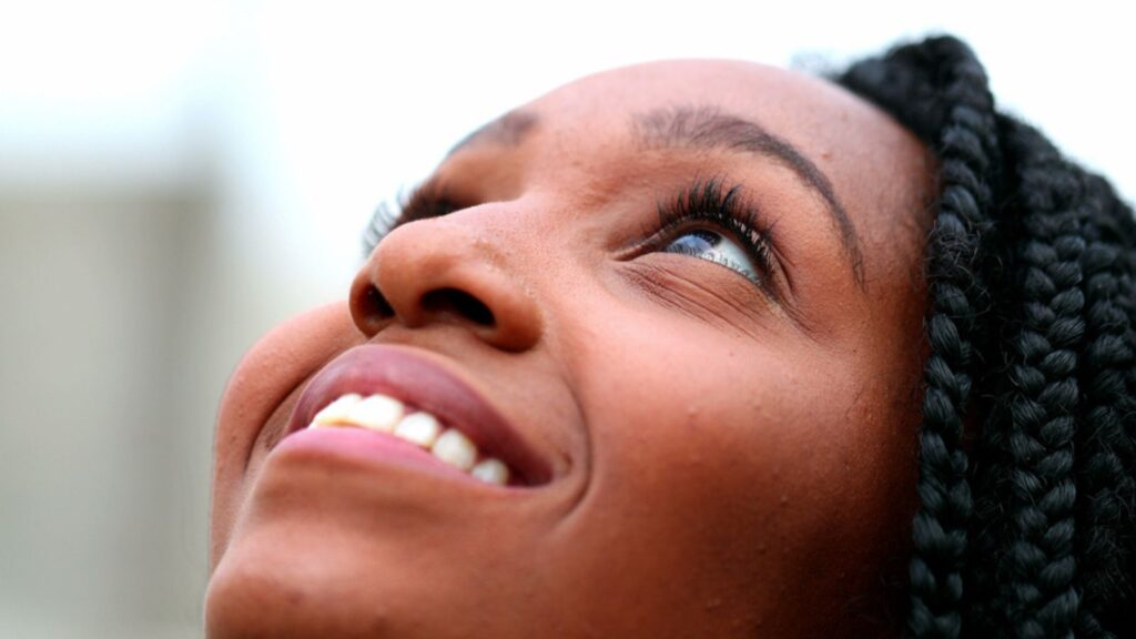 woman looking up to sky feeling freedom and happiness,