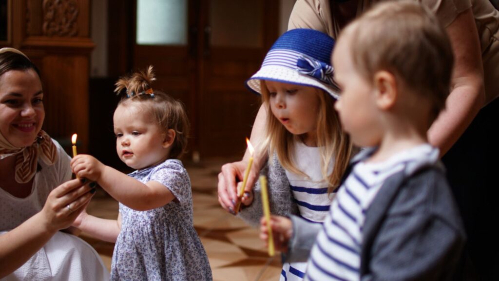 Little children taking the candles, first visit and first impression in a Church
