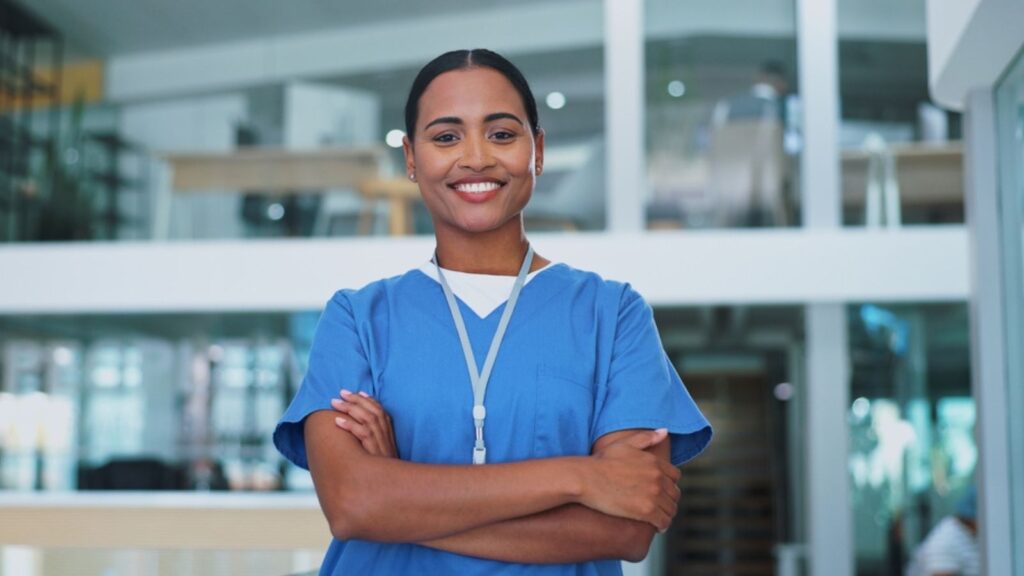 Nurse, woman and arms crossed with portrait, smile and pride for career in healthcare at hospital. Doctor, medical worker or person with confidence for wellness