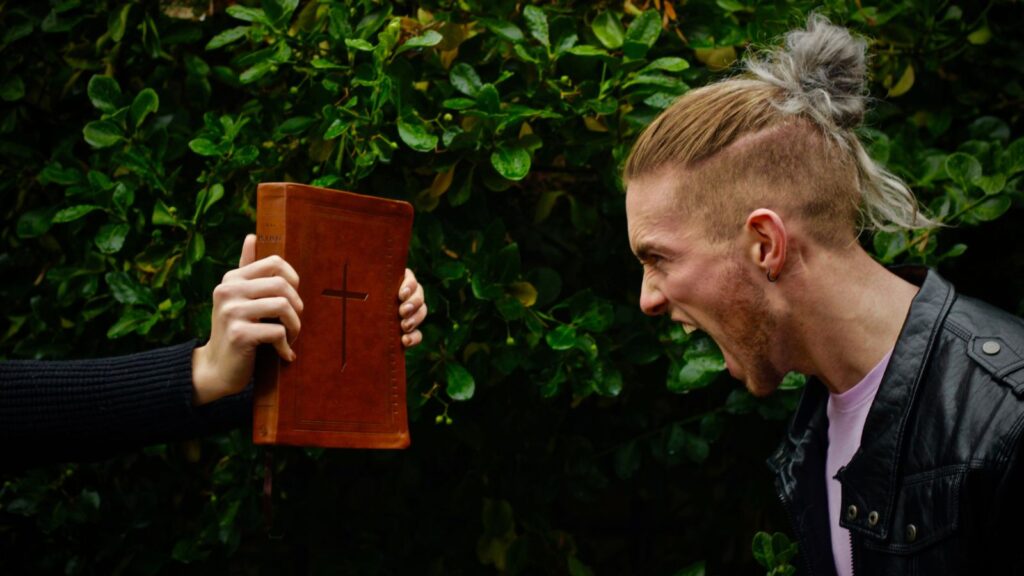 a man screaming at a bible