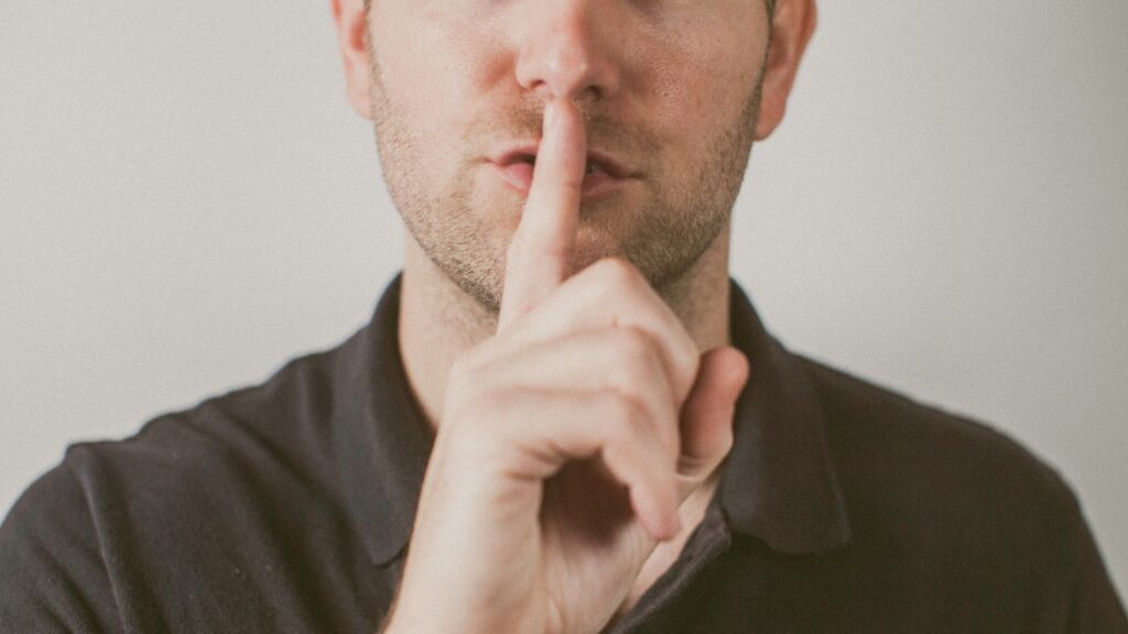 man holding hands over his mouth,silence