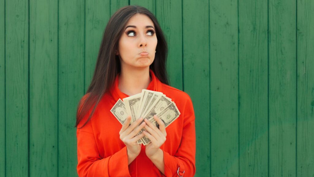 woman,girl Holding Money Ready to Make Payment. Disappointed woman counting the bills for taxes