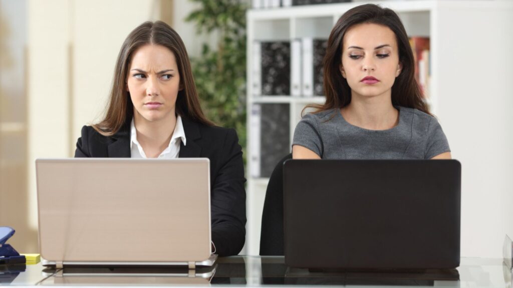angry businesswomen looking each other with hate working with laptops at office,hate enemies